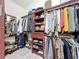 Organized walk-in closet featuring wooden shelves, drawers, and hanging racks for clothes and shoes at 13710 Glossy Ibis Pl, Lakewood Ranch, FL 34202