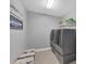 Bright laundry room featuring modern washer and dryer with decor and shelving at 16621 Berwick Ter, Lakewood Ranch, FL 34202