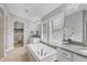 Bright bathroom with a soaking tub, granite countertops, and walk-in closet at 16621 Berwick Ter, Lakewood Ranch, FL 34202