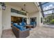 Outdoor living space with comfortable seating area, TV, and access to the pool area at 16621 Berwick Ter, Lakewood Ranch, FL 34202