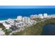 Stunning aerial view of beachfront condos with tennis courts, lush greenery and the Gulf of Mexico in the background at 2100 Benjamin Franklin Dr # 108, Sarasota, FL 34236