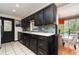 Contemporary kitchen featuring quartz countertops, dark cabinetry, and stainless steel appliances at 2885 Arrowhead Rd, Venice, FL 34293