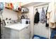 Functional laundry room with washer, dryer, and ample storage shelves at 2885 Arrowhead Rd, Venice, FL 34293