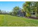 A beautiful green backyard featuring a screened-in patio and well-maintained lawn with lush vegetation at 3922 Wildgrass Pl, Parrish, FL 34219