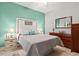 Bright bedroom features soft bedding and a decorative white headboard with rope trim at 3922 Wildgrass Pl, Parrish, FL 34219