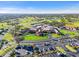 Aerial view showcasing the expansive community clubhouse, golf course, water features, and well-maintained grounds at 6170 Misty Oaks Dr, Sarasota, FL 34243