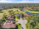 Expansive aerial view of homes in a community with lush landscaping, a golf course, and a lake at 6170 Misty Oaks Dr, Sarasota, FL 34243