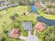 Aerial view of the beautiful community showing mature landscaping, golf course, and serene lake at 6170 Misty Oaks Dr, Sarasota, FL 34243