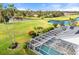 Aerial view of the enclosed pool with mature landscaping and golf course views at 6170 Misty Oaks Dr, Sarasota, FL 34243
