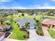 Beautiful aerial view of a landscaped home near a golf course, ponds, and other neighborhood houses at 6170 Misty Oaks Dr, Sarasota, FL 34243