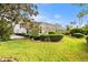 Expansive backyard view showcases mature landscaping, manicured lawn, and screened lanai at 6170 Misty Oaks Dr, Sarasota, FL 34243