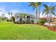 Charming single Gathering home with lush landscaping, a well-manicured lawn, and a paved driveway at 6170 Misty Oaks Dr, Sarasota, FL 34243