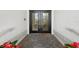 Elegant front door with decorative glass inserts and a welcoming 'Hello' mat on a patterned stone porch at 6170 Misty Oaks Dr, Sarasota, FL 34243