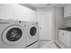Functional laundry room with modern washer and dryer, and sleek white cabinets at 6170 Misty Oaks Dr, Sarasota, FL 34243