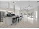 Open-concept living space with a breakfast bar, tile floors, and modern lighting at 6170 Misty Oaks Dr, Sarasota, FL 34243