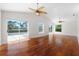 Hardwood flooring and a ceiling fan accent this light and airy living room at 6170 Misty Oaks Dr, Sarasota, FL 34243