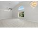 Bright, open living room with vaulted ceilings, white tile floors, and large windows allowing ample sunlight at 6170 Misty Oaks Dr, Sarasota, FL 34243
