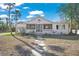 Charming home with a screened-in porch and stone walkway, complemented by mature landscaping at 624 Norsota Way, Sarasota, FL 34242