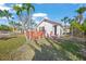 Home exterior with a red deck and lush landscaping providing a private and inviting outdoor space at 624 Norsota Way, Sarasota, FL 34242