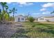 Cozy home exterior with lush green lawn, tropical palms, and a charming, inviting facade at 624 Norsota Way, Sarasota, FL 34242