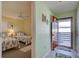 Condo hallway adjacent to a bedroom with two twin beds featuring tropical patterned bedding at 6800 Placida Rd # 2017, Englewood, FL 34224