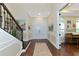 Elegant foyer with dark hardwood floors, staircase, and detailed trim and double front doors at 7315 Bianco Duck Ct, Sarasota, FL 34240