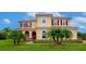 Beautiful two-story home with manicured lawn and decorative palm trees in a well landscaped front yard at 7315 Bianco Duck Ct, Sarasota, FL 34240
