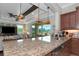 Modern kitchen island featuring granite countertops, stainless steel dishwasher, and decorative pendant lights at 7315 Bianco Duck Ct, Sarasota, FL 34240