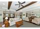 Open-concept living room with hardwood floors, ceiling beams, and seamless access to kitchen and dining areas at 7315 Bianco Duck Ct, Sarasota, FL 34240
