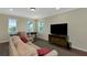 Spacious living room featuring hardwood floors, a large TV, and a foosball table for entertaining at 7315 Bianco Duck Ct, Sarasota, FL 34240