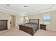 Elegant bedroom with tray ceilings, carpeted floors, and a view of the outdoors at 7315 Bianco Duck Ct, Sarasota, FL 34240