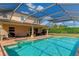 The screened in pool has an attached spa, brick patio, and view of the backyard and the home's exterior at 7315 Bianco Duck Ct, Sarasota, FL 34240