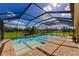 Inviting screened pool with a brick patio and lush greenery in the background at 7315 Bianco Duck Ct, Sarasota, FL 34240