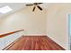 A well-lit area featuring hardwood floors, a ceiling fan, and a glass-paneled railing at 16 Tidy Island Blvd # 16, Bradenton, FL 34210