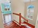 Staircase with wood and glass railing leads to a room with large windows and hardwood floors at 16 Tidy Island Blvd # 16, Bradenton, FL 34210