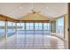 Enclosed sunroom featuring tile flooring, a ceiling fan, and large windows with water views at 16 Tidy Island Blvd # 16, Bradenton, FL 34210