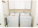 Functional laundry room with white washer and dryer, and overhead storage cabinets at 1801 Gulf N Dr # 175, Bradenton Beach, FL 34217