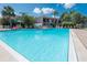 Community pool with lounge chairs, lush landscaping, and clear blue water, perfect for relaxation at 1801 Gulf N Dr # 175, Bradenton Beach, FL 34217