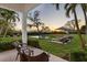 Tranquil backyard featuring a pool, lush lawn, lounge chairs, and a picturesque sunset view at 3930 Red Rock Way, Sarasota, FL 34231