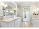 Bright bathroom with a marble counter, white cabinets, and a doorway to an outdoor space at 3930 Red Rock Way, Sarasota, FL 34231