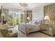 Bright bedroom with a canopy bed, light walls, woven seating, and french doors leading to the outside at 3930 Red Rock Way, Sarasota, FL 34231