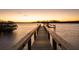 Scenic waterfront wooden dock stretching into the serene water, offering a tranquil spot to enjoy the beautiful sunset views at 3930 Red Rock Way, Sarasota, FL 34231