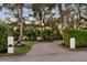 Elegant home featuring a circular brick driveway, lush tropical landscaping, and inviting exterior architecture at 3930 Red Rock Way, Sarasota, FL 34231