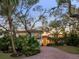 Elegant exterior with a brick driveway, red-tiled roof, and mature trees at 3930 Red Rock Way, Sarasota, FL 34231