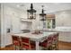 Bright kitchen with white cabinetry, marble countertops, a large island, and pendant lights at 3930 Red Rock Way, Sarasota, FL 34231