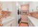 Efficient laundry room with stacked appliances, red patterned wallpaper, and ample white storage cabinets at 3930 Red Rock Way, Sarasota, FL 34231