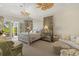 Serene bedroom featuring a four-poster bed, sitting area, and access to a patio at 3930 Red Rock Way, Sarasota, FL 34231