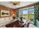 Comfortable home office with wood paneling, a ceiling fan, and a view of the pool at 3930 Red Rock Way, Sarasota, FL 34231