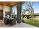 Outdoor dining area features a stone patio, built-in grill, and a view of the pool and manicured landscaping at 3930 Red Rock Way, Sarasota, FL 34231