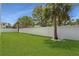 A spacious backyard has a well-maintained lawn, privacy fence, and mature trees that provide a serene outdoor space at 630 Companion Way, Longboat Key, FL 34228